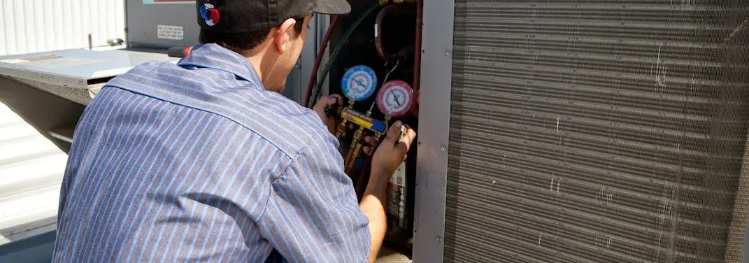HVAC technician servicing a condenser unit in Susanville